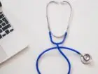 Kiedy przysługuje zasiłek chorobowy - stetoskop i laptop na białym blacie