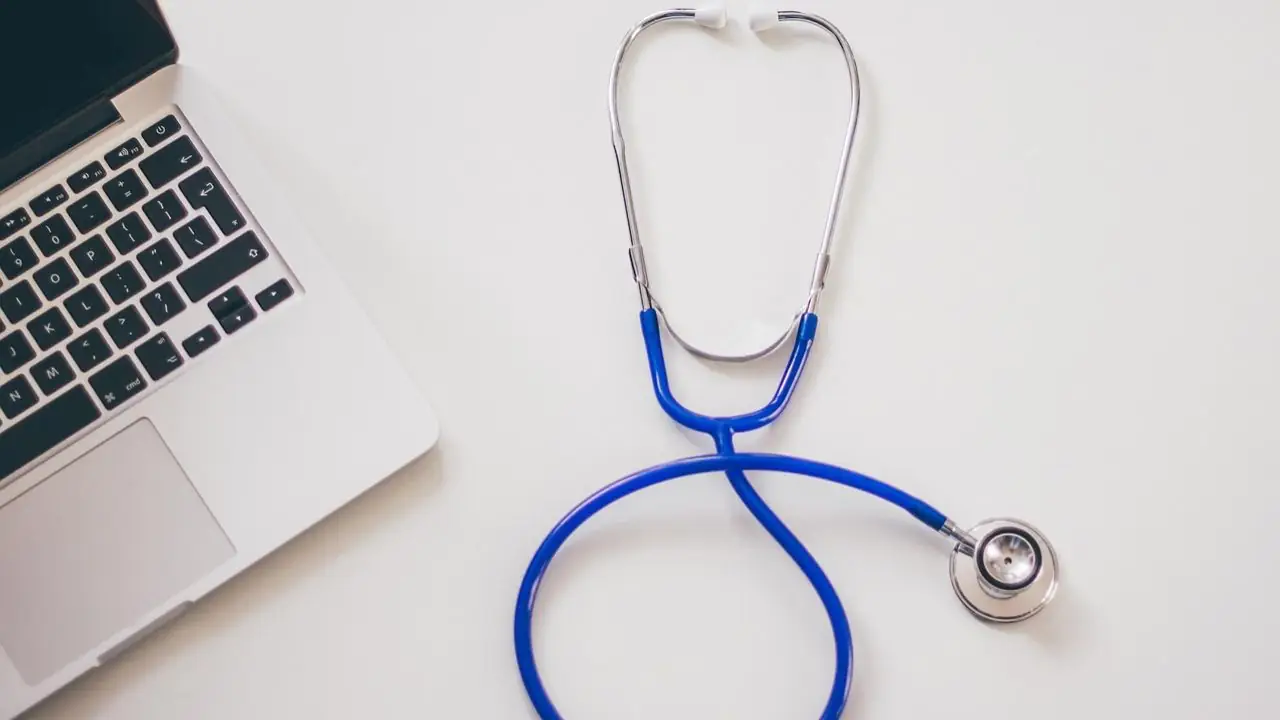 Kiedy przysługuje zasiłek chorobowy - stetoskop i laptop na białym blacie