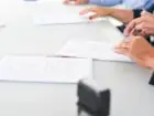 Przedłużenie umowy zlecenia - wzór - ludzie podpisujący dokumenty przy stole