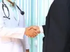 Kiedy zanieść zwolnienie do ZUS - lekarz podający dłoń przedsiębiorcy