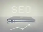Pozycjonowanie Poznań - napis SEO nad laptopem