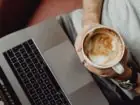 Home office - co to - kawa w dłoni przy laptopie