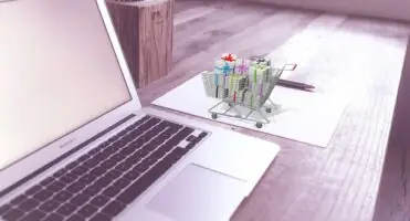 Tanie paczki z Chin - wózek z paczkami przy laptopie