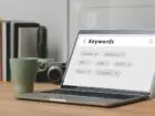 Pozycjonowanie Kraków - laptop z hasłami SEO