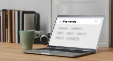 Pozycjonowanie Kraków - laptop z hasłami SEO