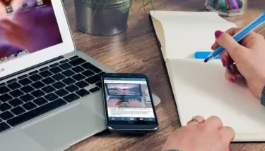 UX writing - laptop, telefon i pisanie w notatniku