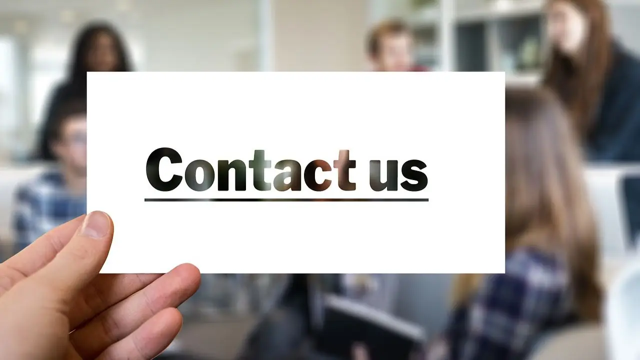 Wizytówka Google - contact us napis na wizytówce na tle zespołu ludzi