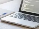 Chrome DevTools - komputer na biurku obok notesu z długopisem