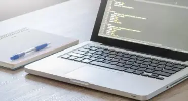 Chrome DevTools - komputer na biurku obok notesu z długopisem