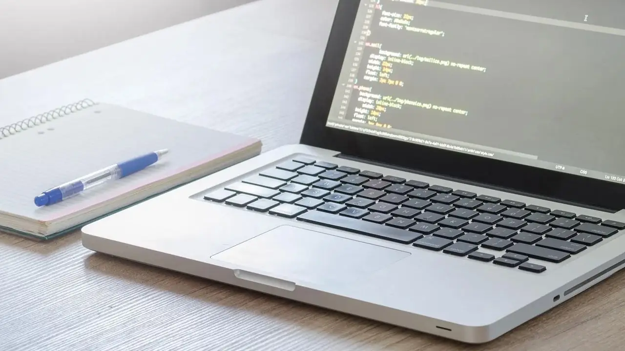 Chrome DevTools - komputer na biurku obok notesu z długopisem